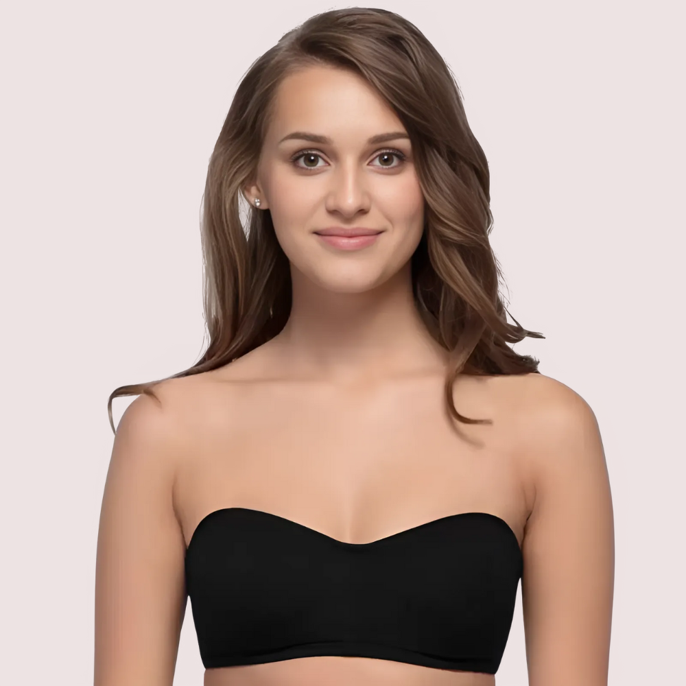 Woman wearing a black strapless top against a plain background