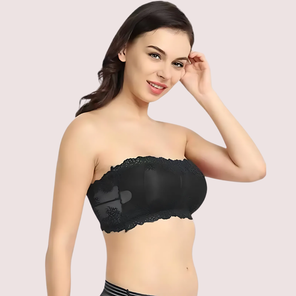 Woman wearing a black strapless bra against a light background