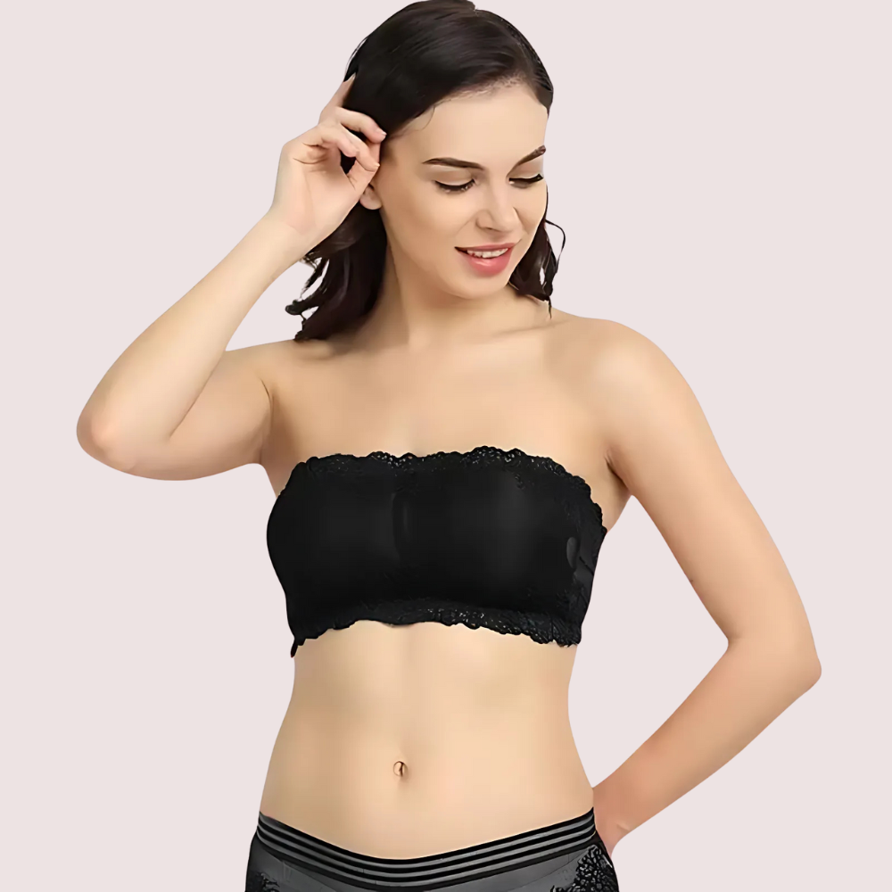 Woman wearing a black strapless top against a plain background