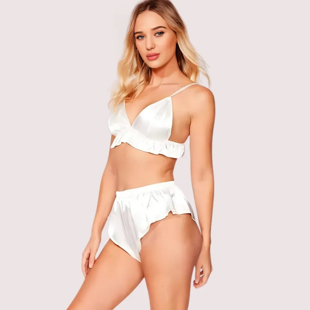 Woman wearing a white satin lingerie set on a light pink background