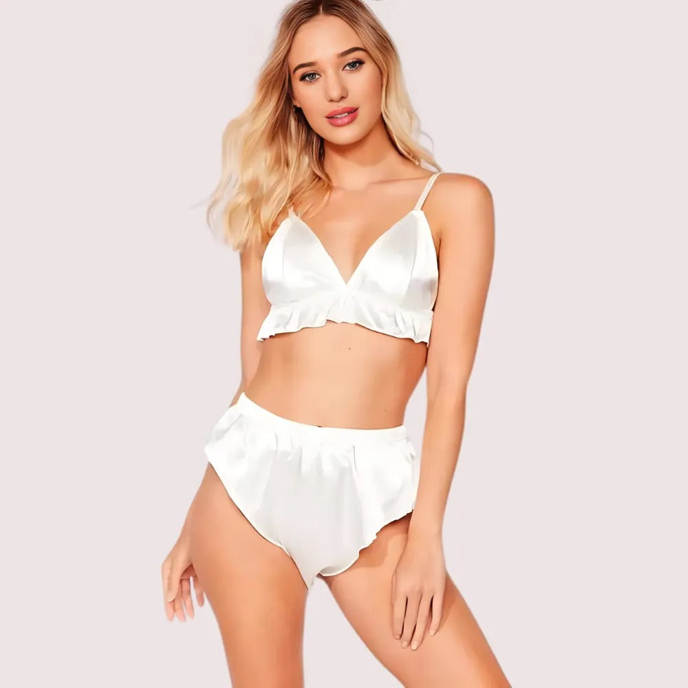 Woman wearing a white satin bikini set on a plain background