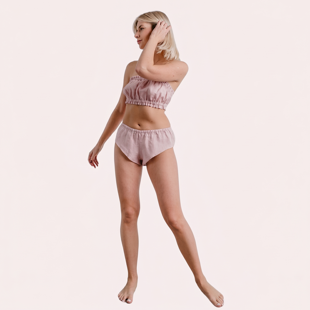 Woman wearing a pink bikini set on a light beige background