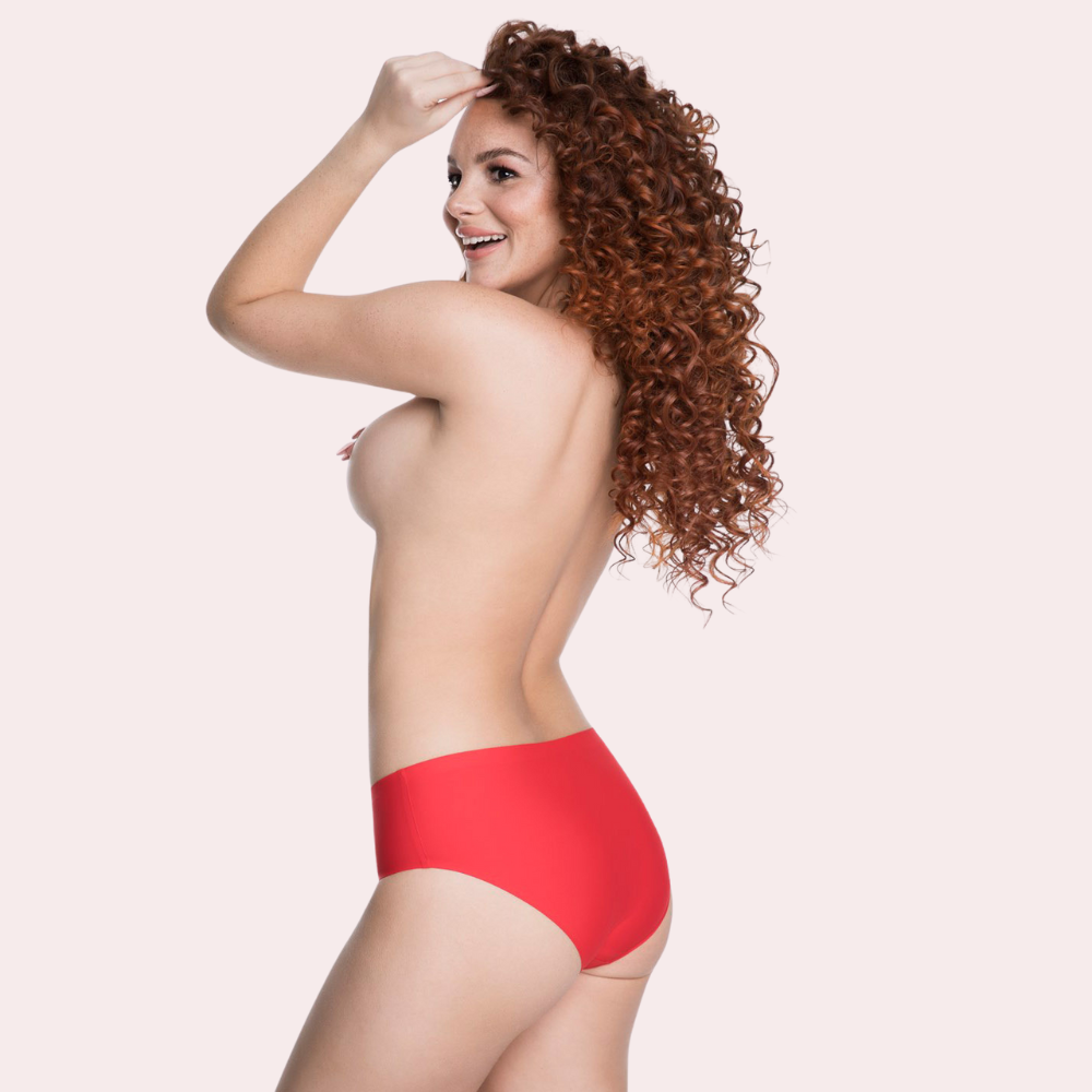 Woman wearing red underwear on a plain background