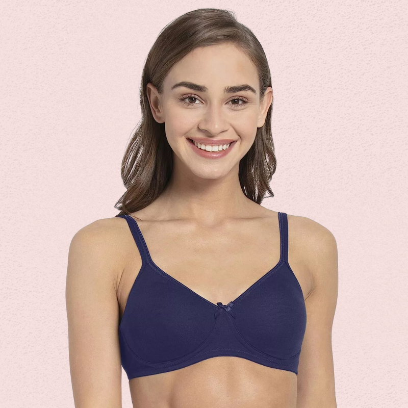 Woman wearing a blue bra against a pink background