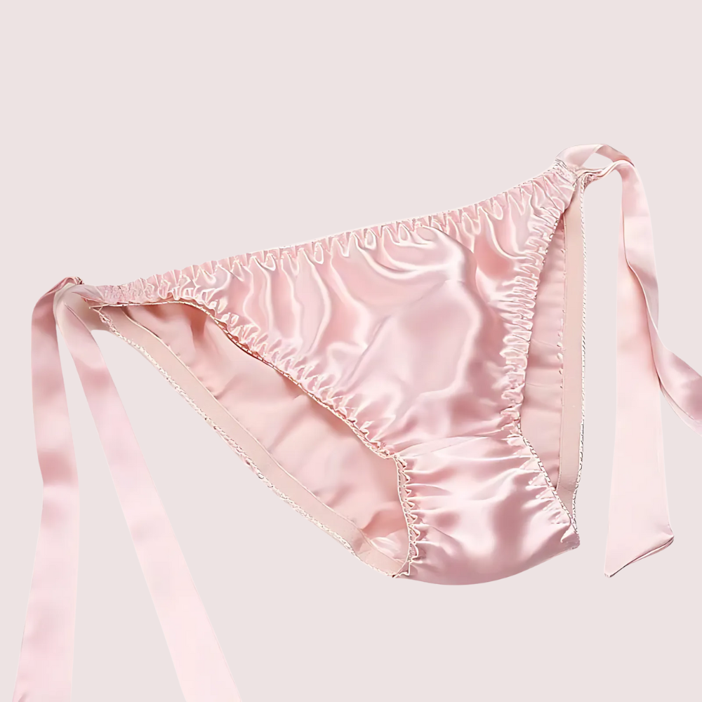 Pink satin lingerie set on a light pink background