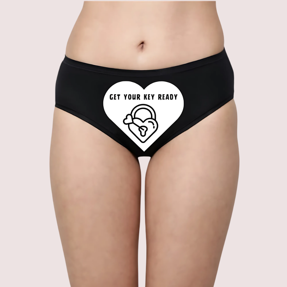 Black underwear with a white heart design and text on a beige background