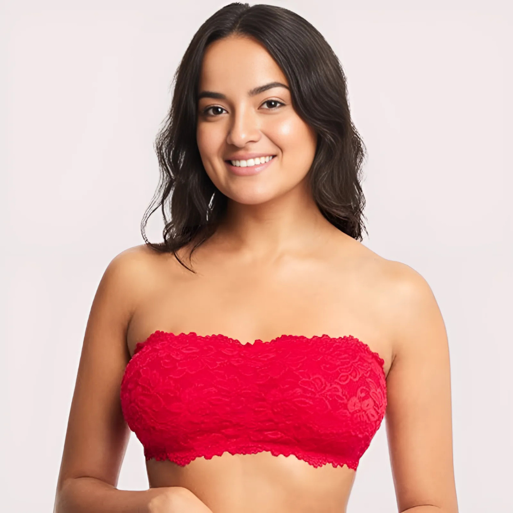 Woman wearing a red lace strapless top against a plain background