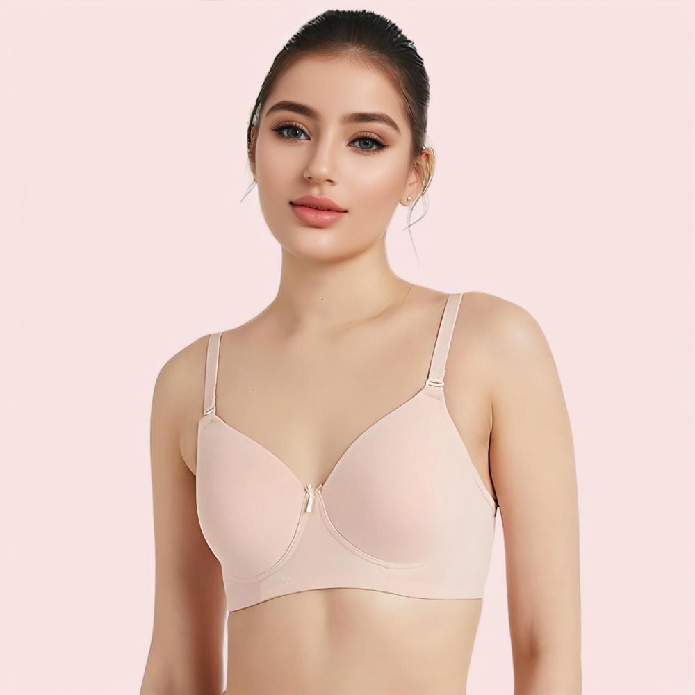 Woman wearing a beige bra against a pink background