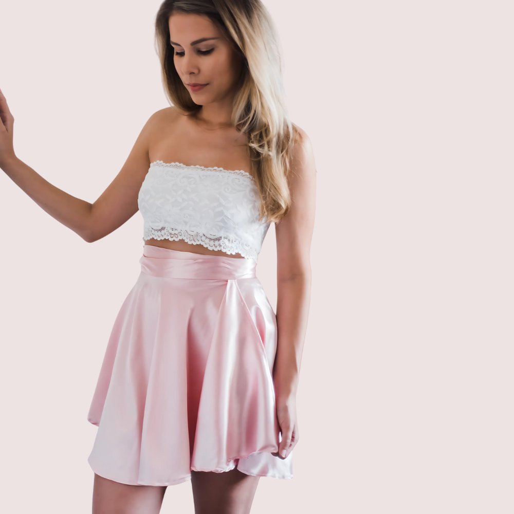 Woman wearing a white lace top and pink skirt 