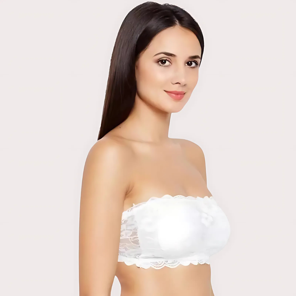 Woman wearing a white strapless top against a plain background