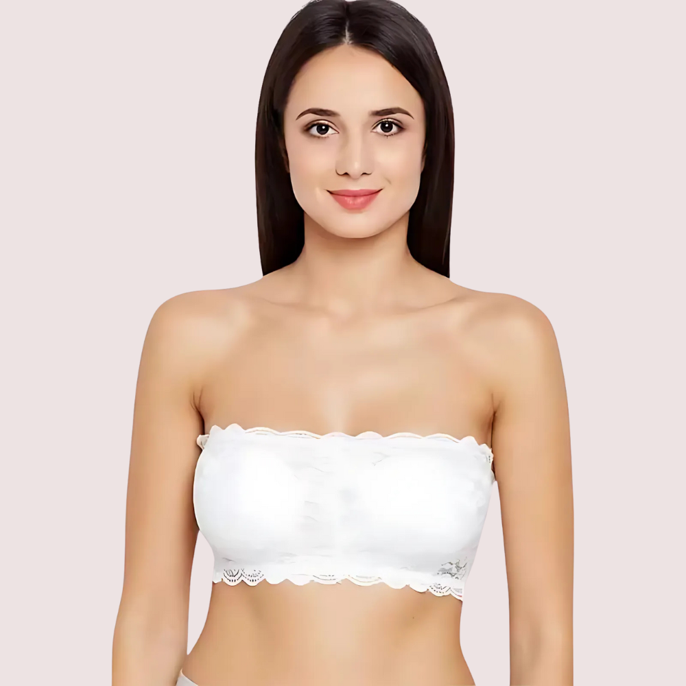 Woman wearing a white strapless top against a light pink background