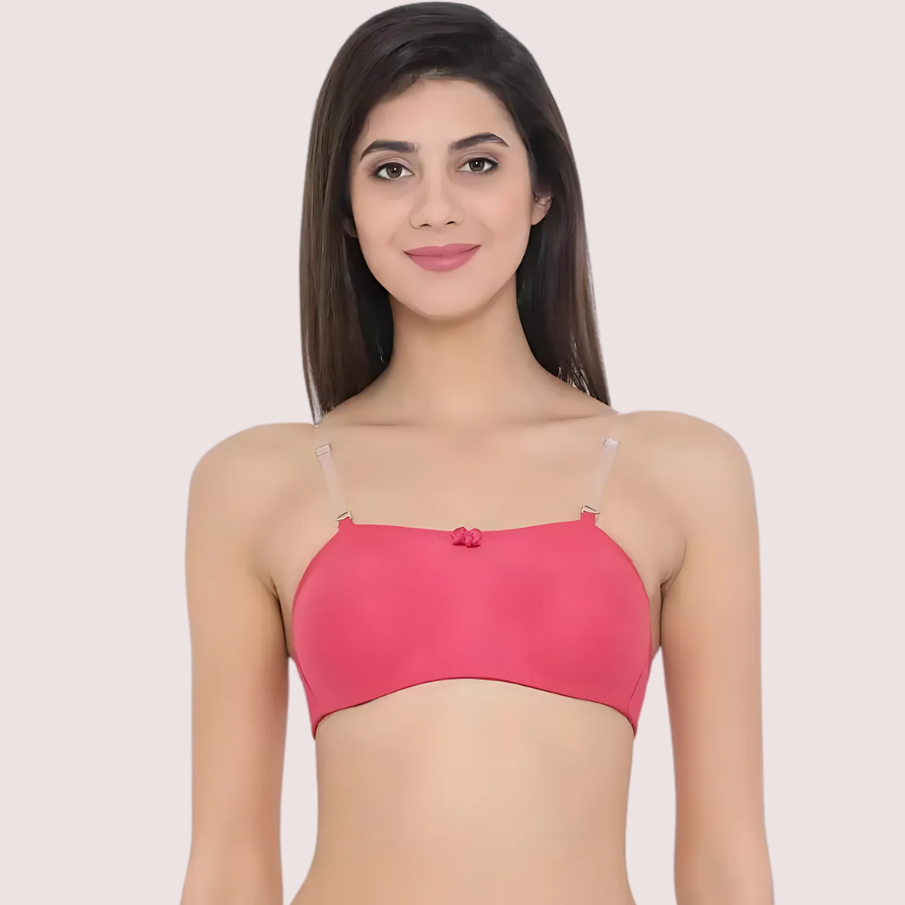 Woman wearing a pink bralette against a plain background