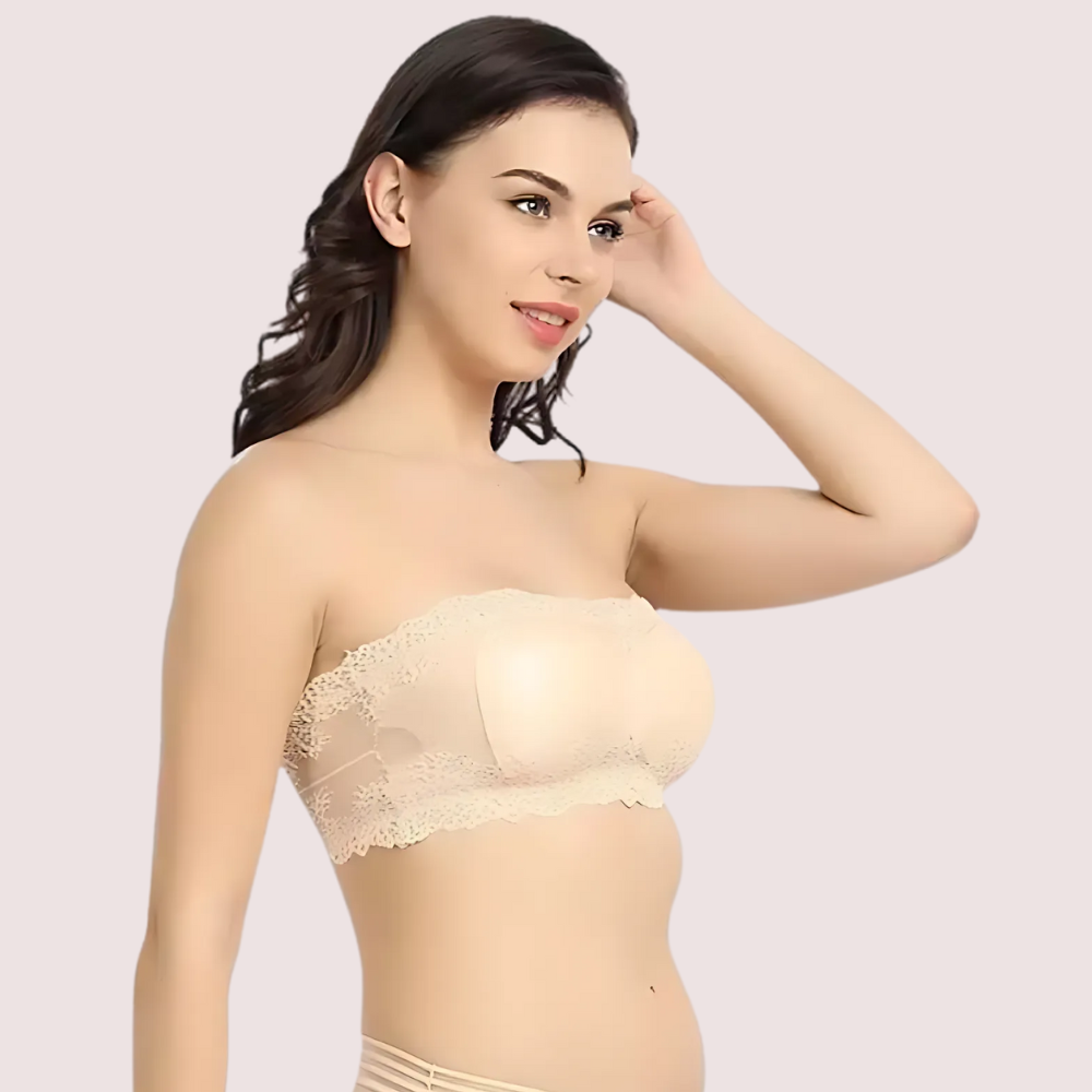 Woman wearing a beige strapless bra against a plain background