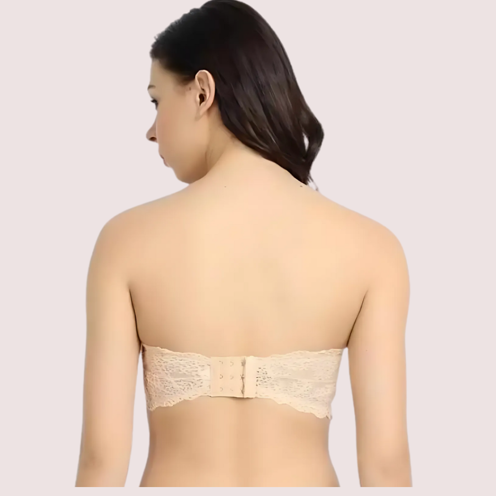 Woman wearing a beige strapless bra on a plain background