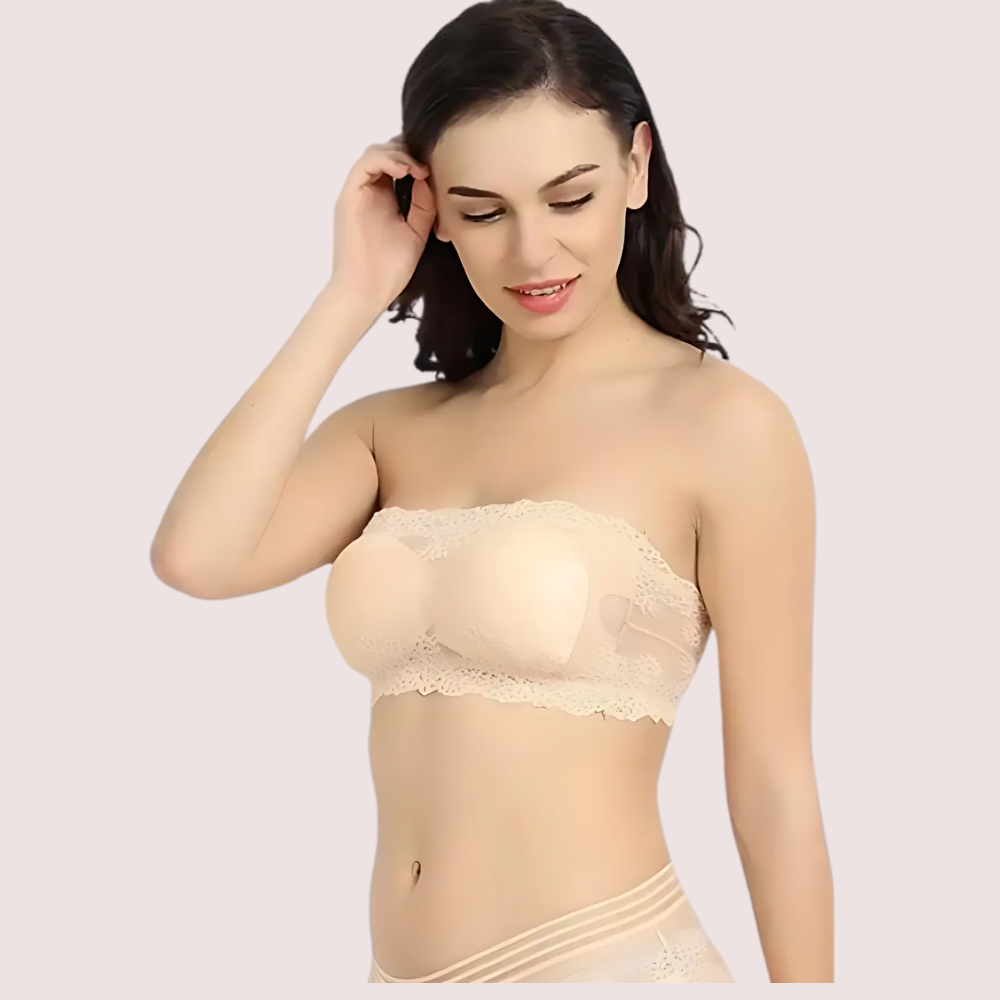 Woman wearing a beige strapless bra against a plain background