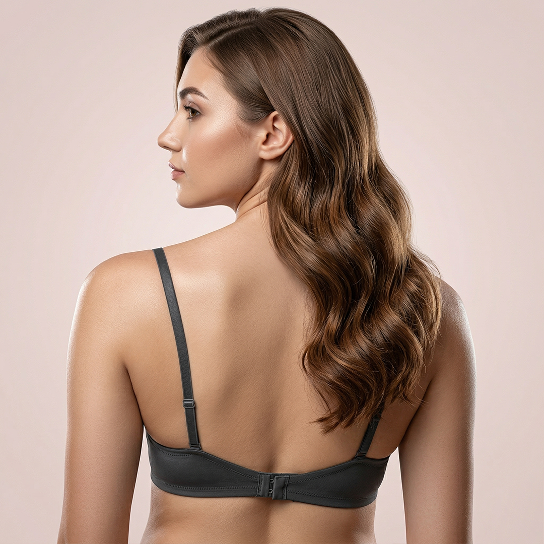 Woman wearing a black bralette against a beige background