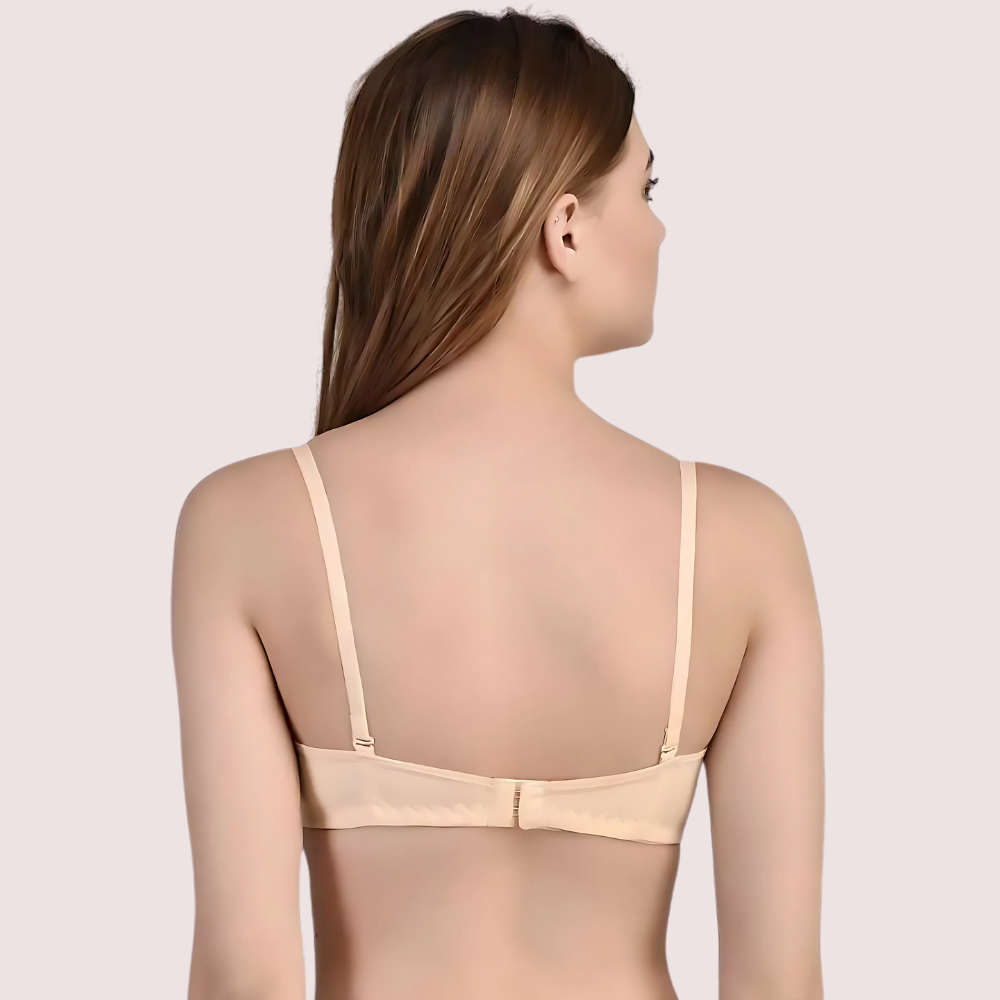 Woman wearing a beige bralette on a light pink background