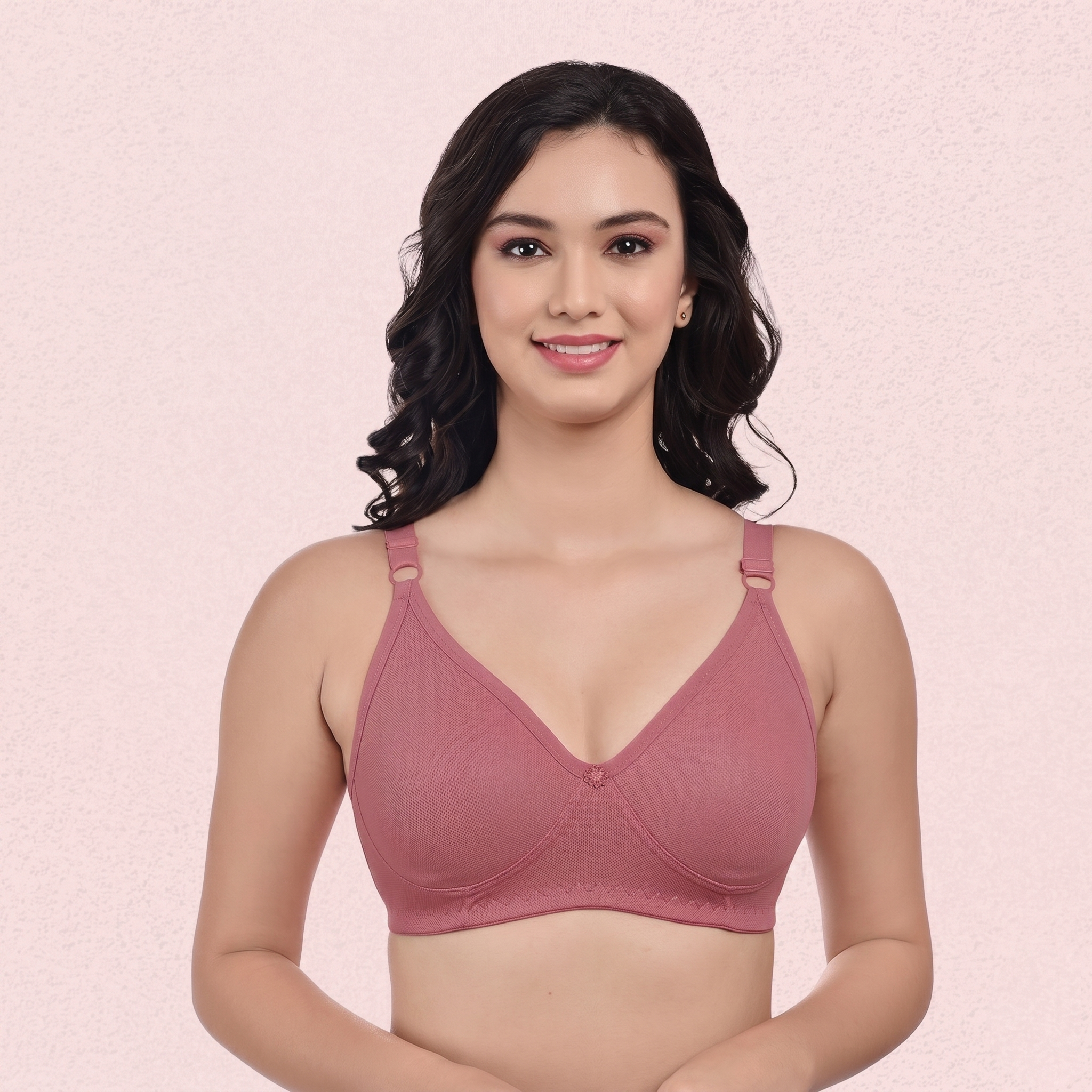 Woman wearing a pink bra against a light pink background