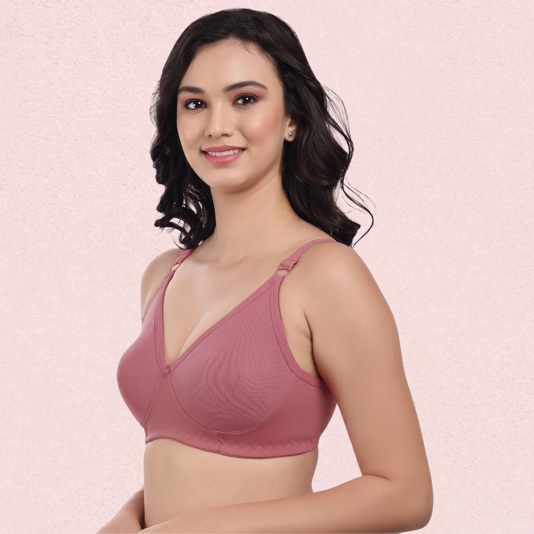 Woman wearing a pink bra against a light pink background