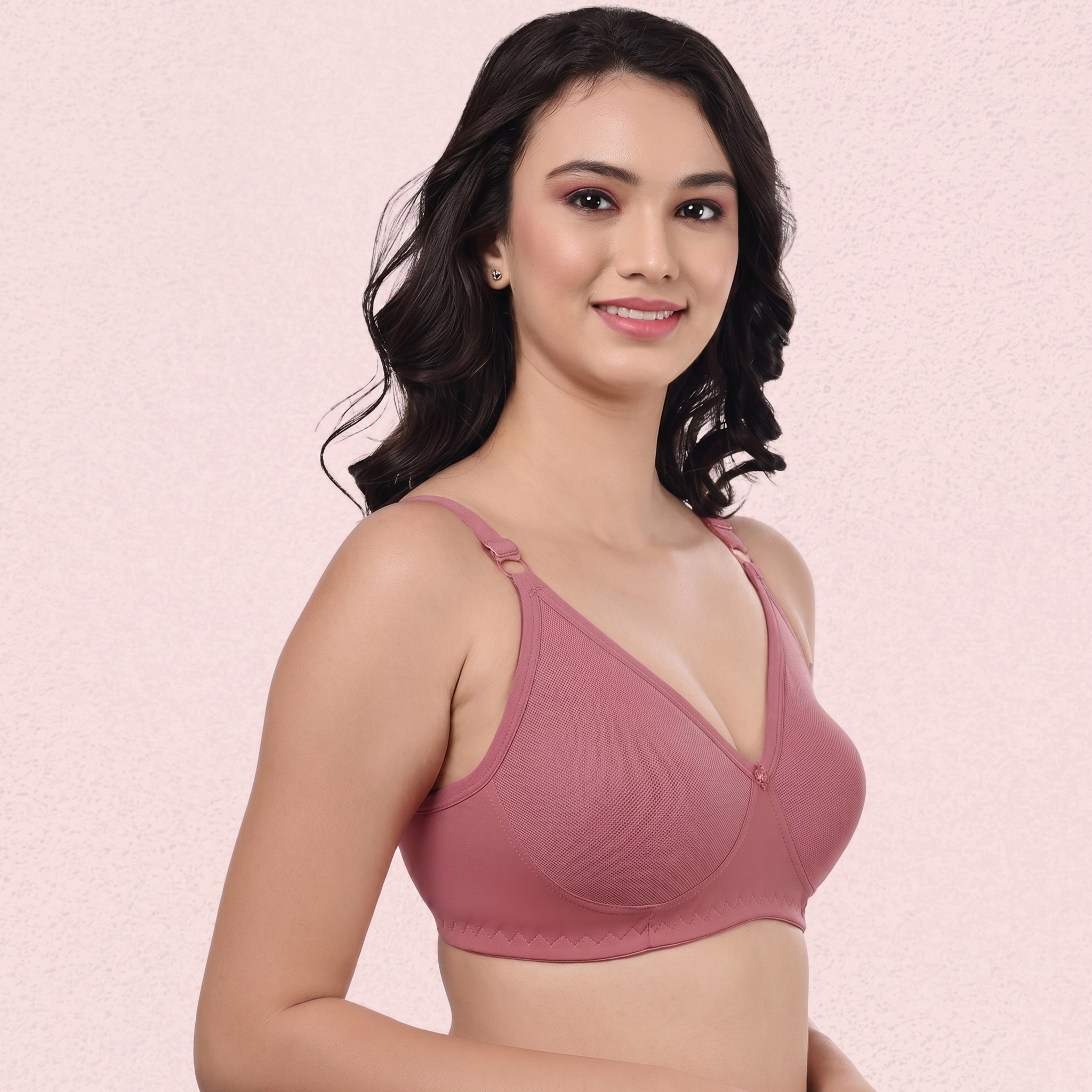 Woman wearing a pink bra against a light pink background