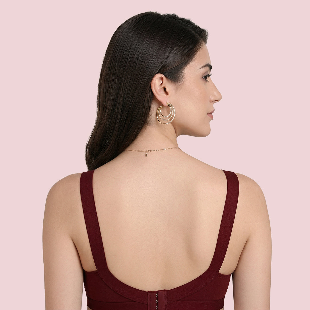 Woman wearing a burgundy top with thin straps 