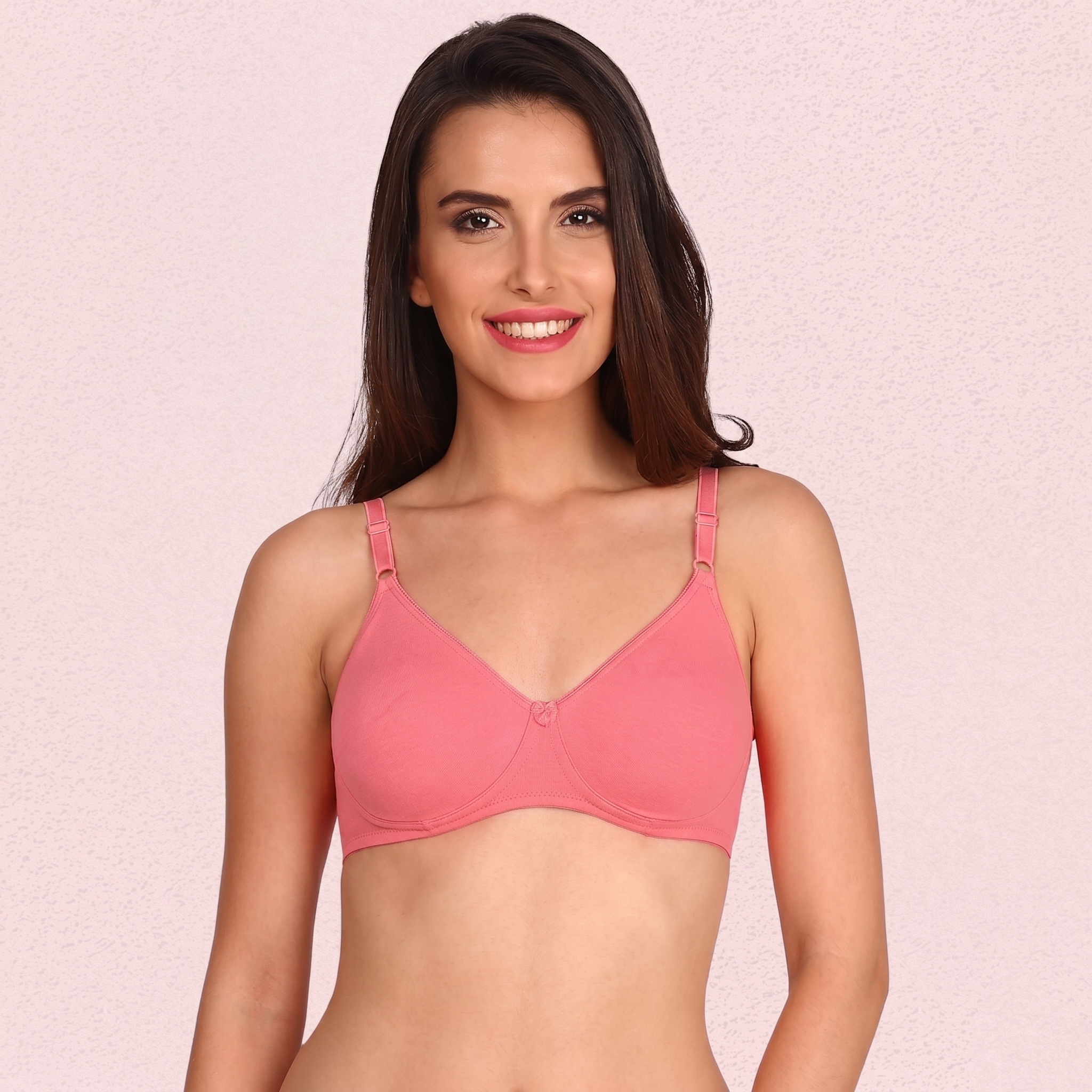 Woman wearing a pink bra against a pink background