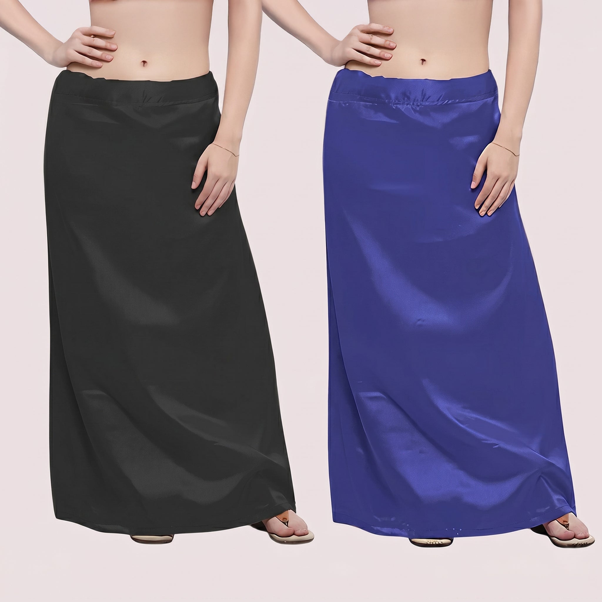 Two people wearing long satin skirts, one black and one blue, on a plain background.