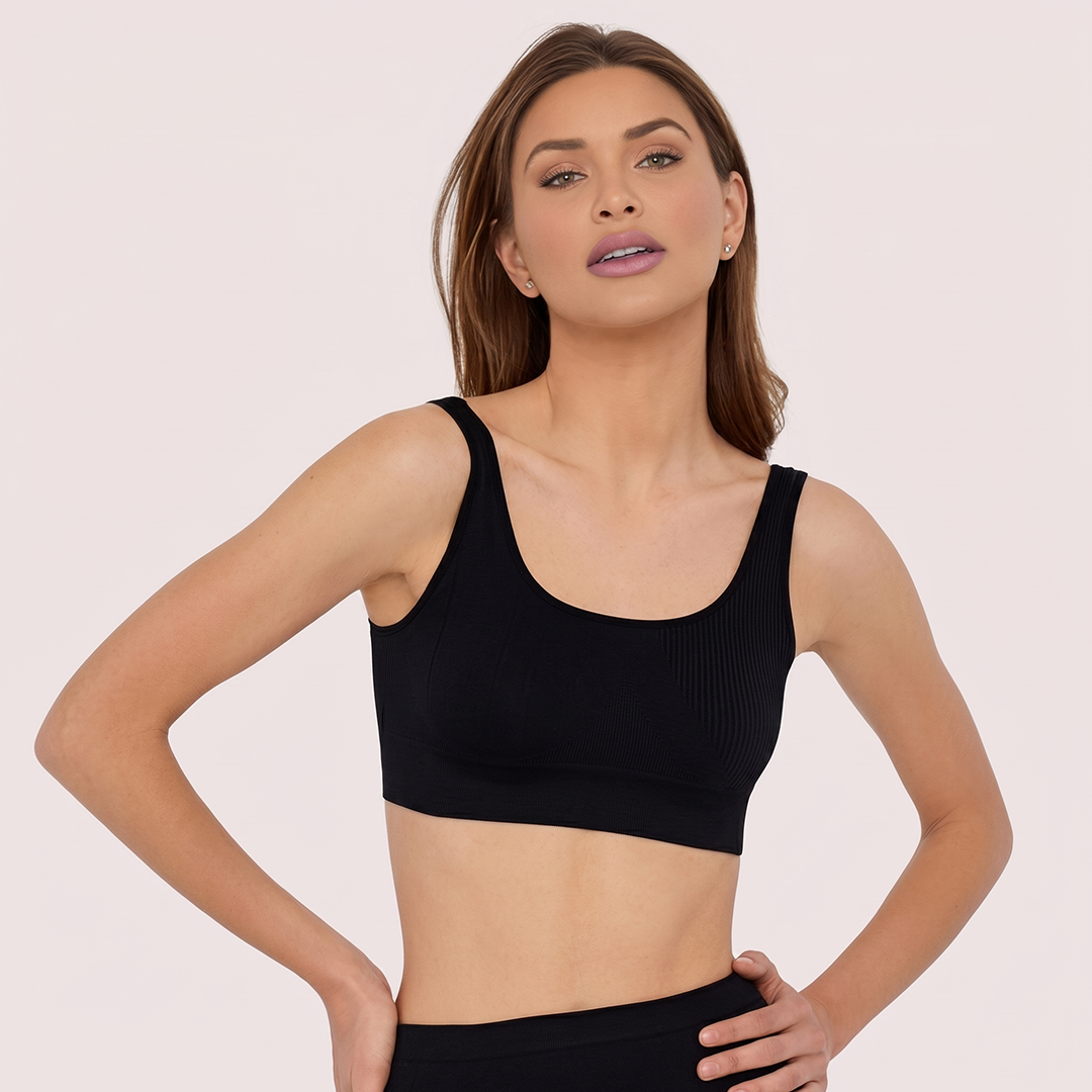 Woman wearing a black sports bra against a plain background