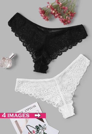Black and white lace lingerie set on a gray background with flowers and a perfume bottle.