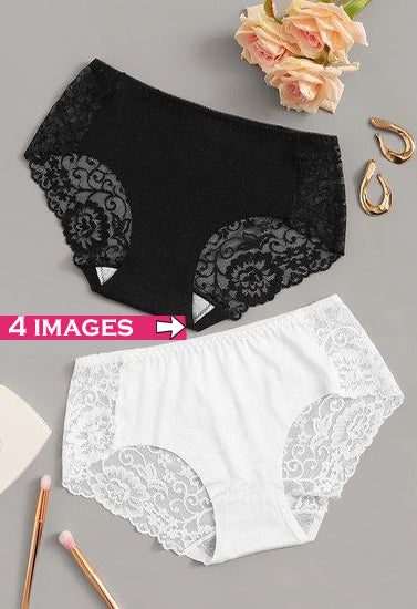 Black and white lace underwear on a gray surface with flowers and jewelry.