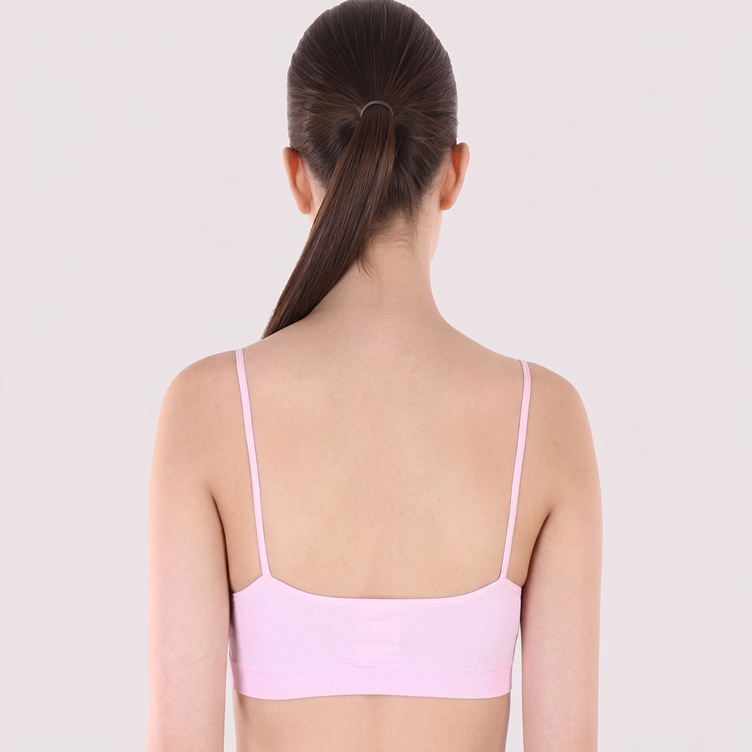 Person wearing a light pink bralette on a plain background