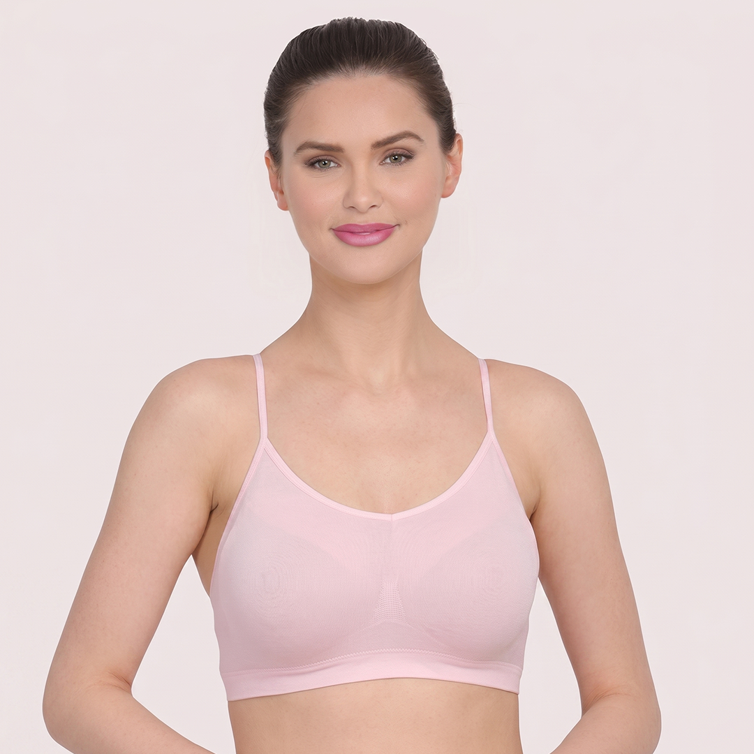 Woman wearing a pink sports bra against a light pink background