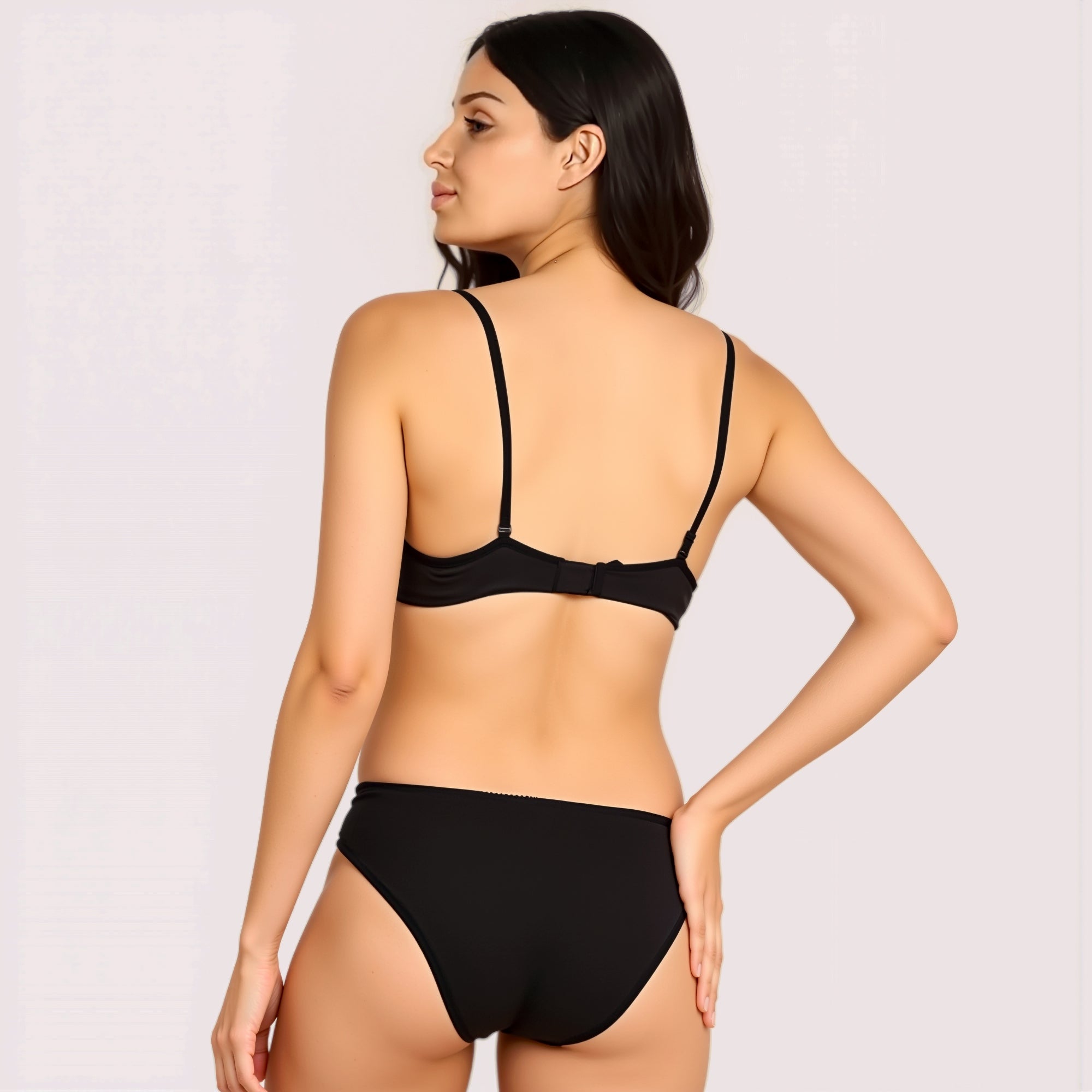 Woman wearing a black bikini on a plain background