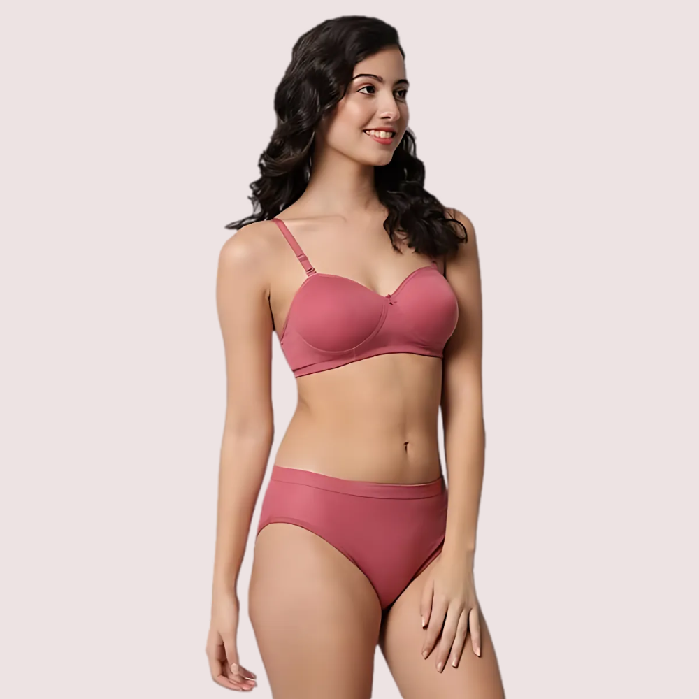 Woman wearing a pink bikini set on a plain background