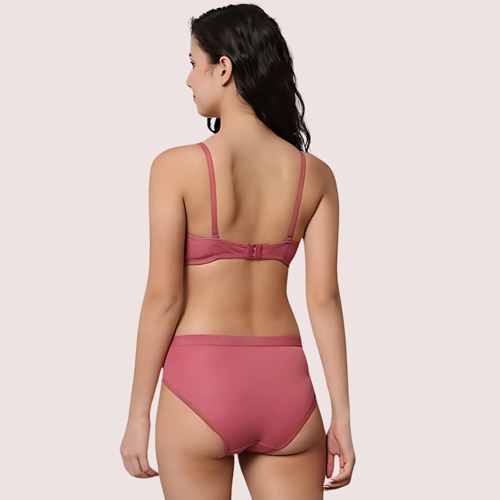 Woman wearing a pink bikini on a plain background