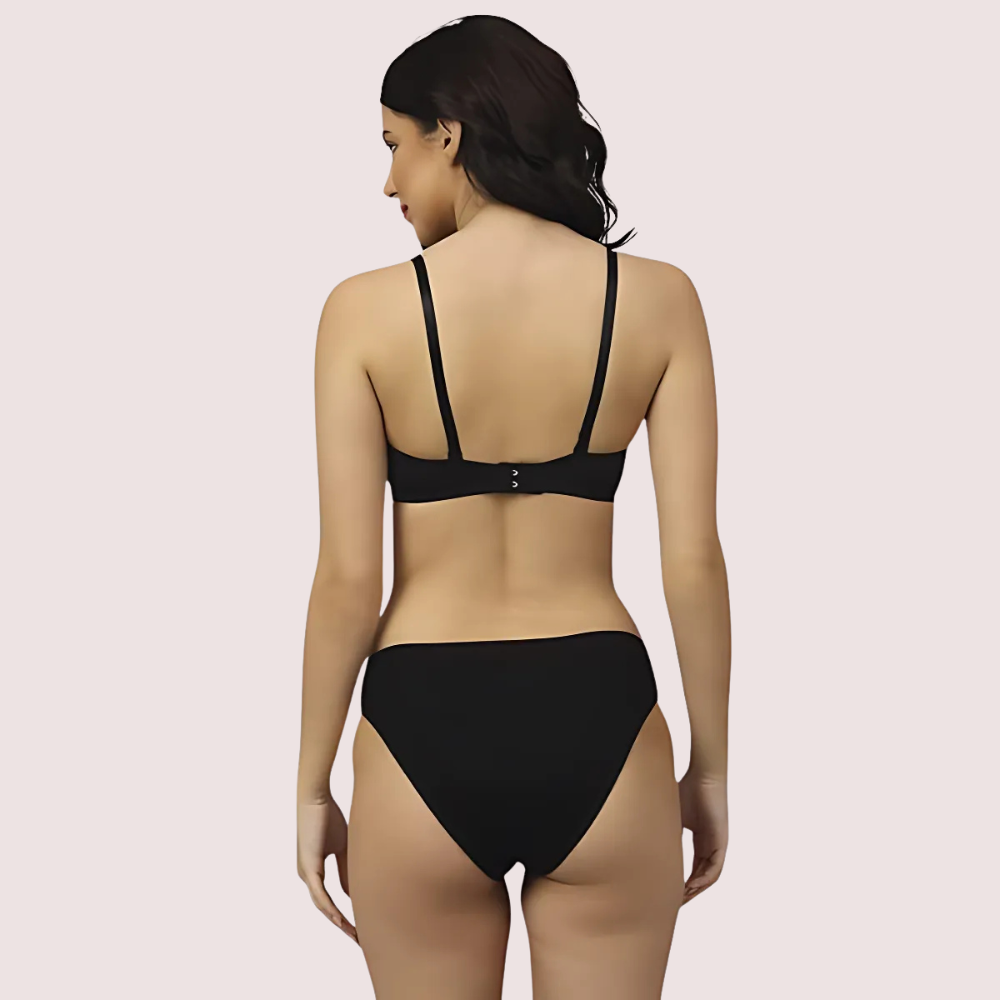 Woman wearing a black bikini on a beige background