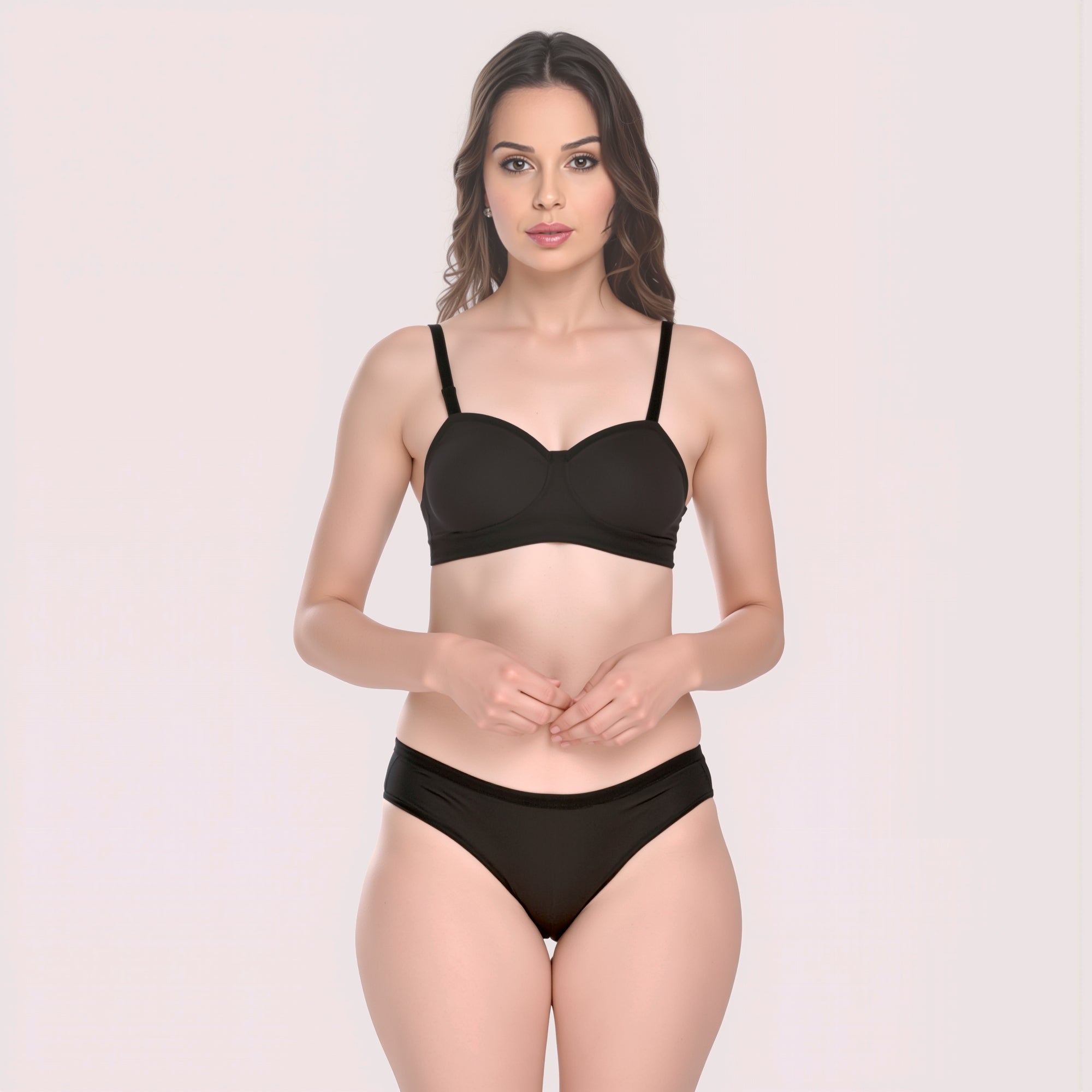 Woman wearing a black bra and panties set on a light pink background