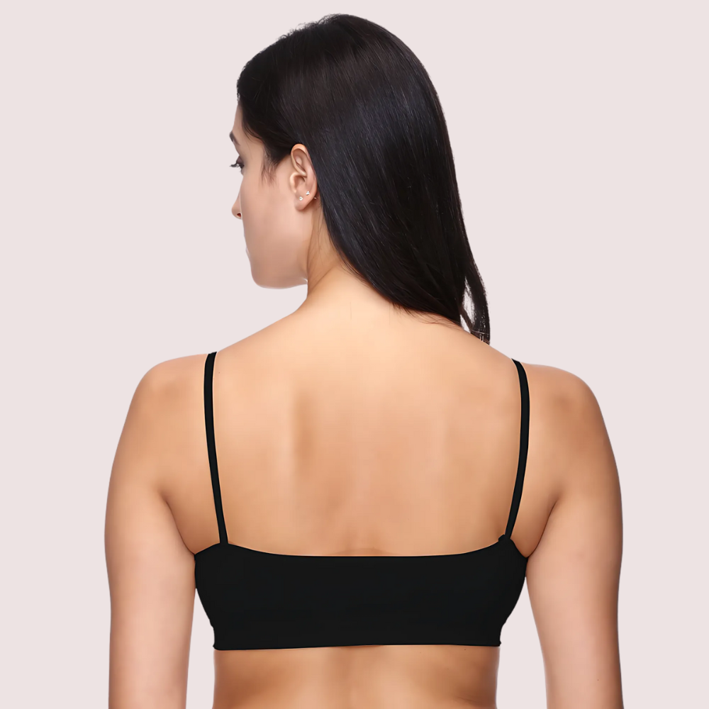 Woman wearing a black bralette on a beige background