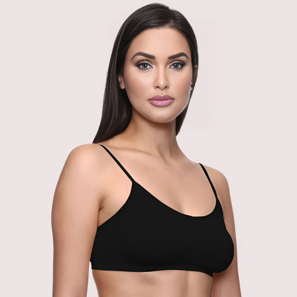 Woman wearing a black bralette against a light pink background