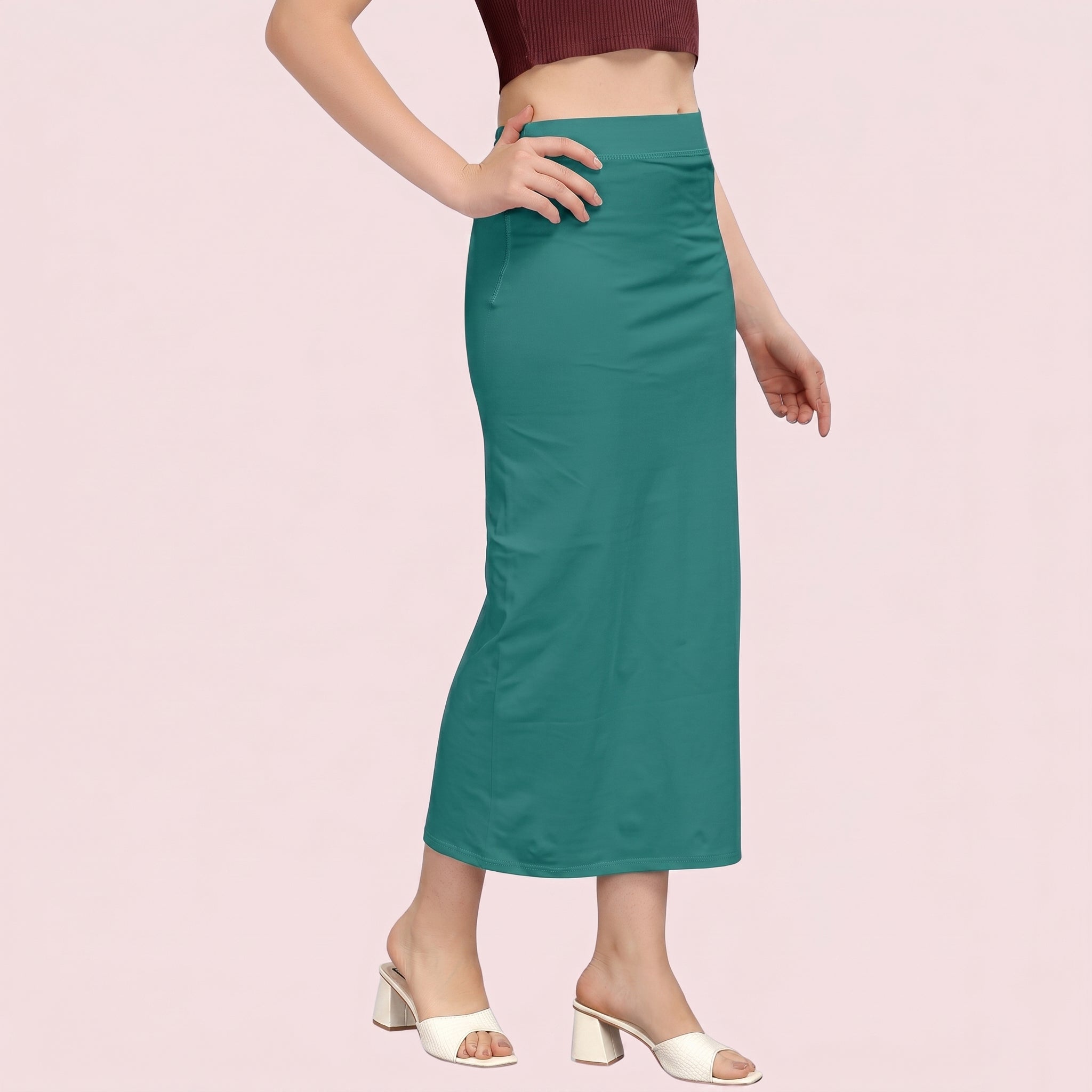 Teal skirt worn by a person on a pink background