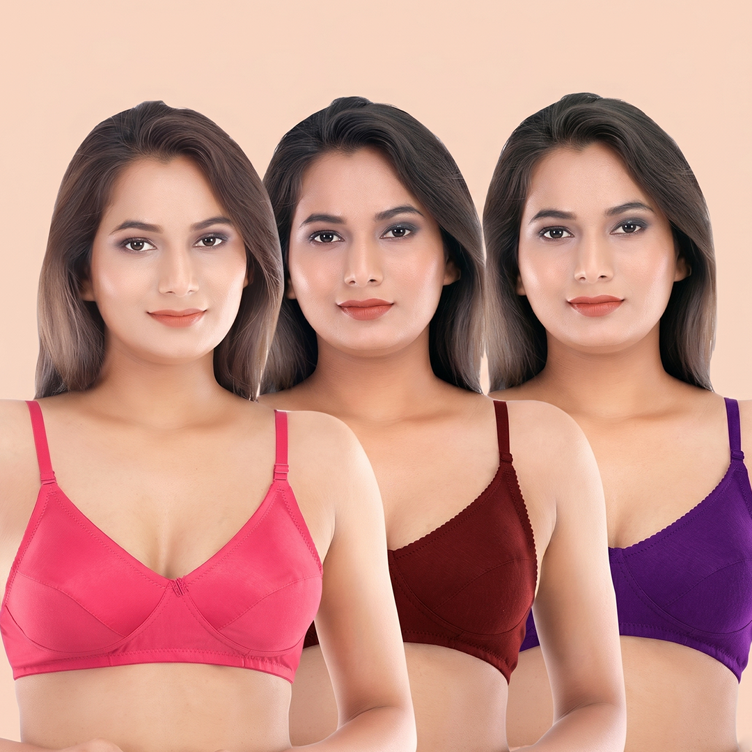 Three women wearing pink, red, and purple bras against a beige background