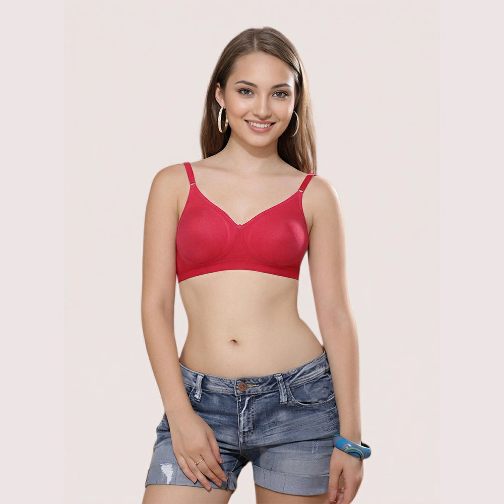 Woman wearing a red bra and denim shorts on a plain background