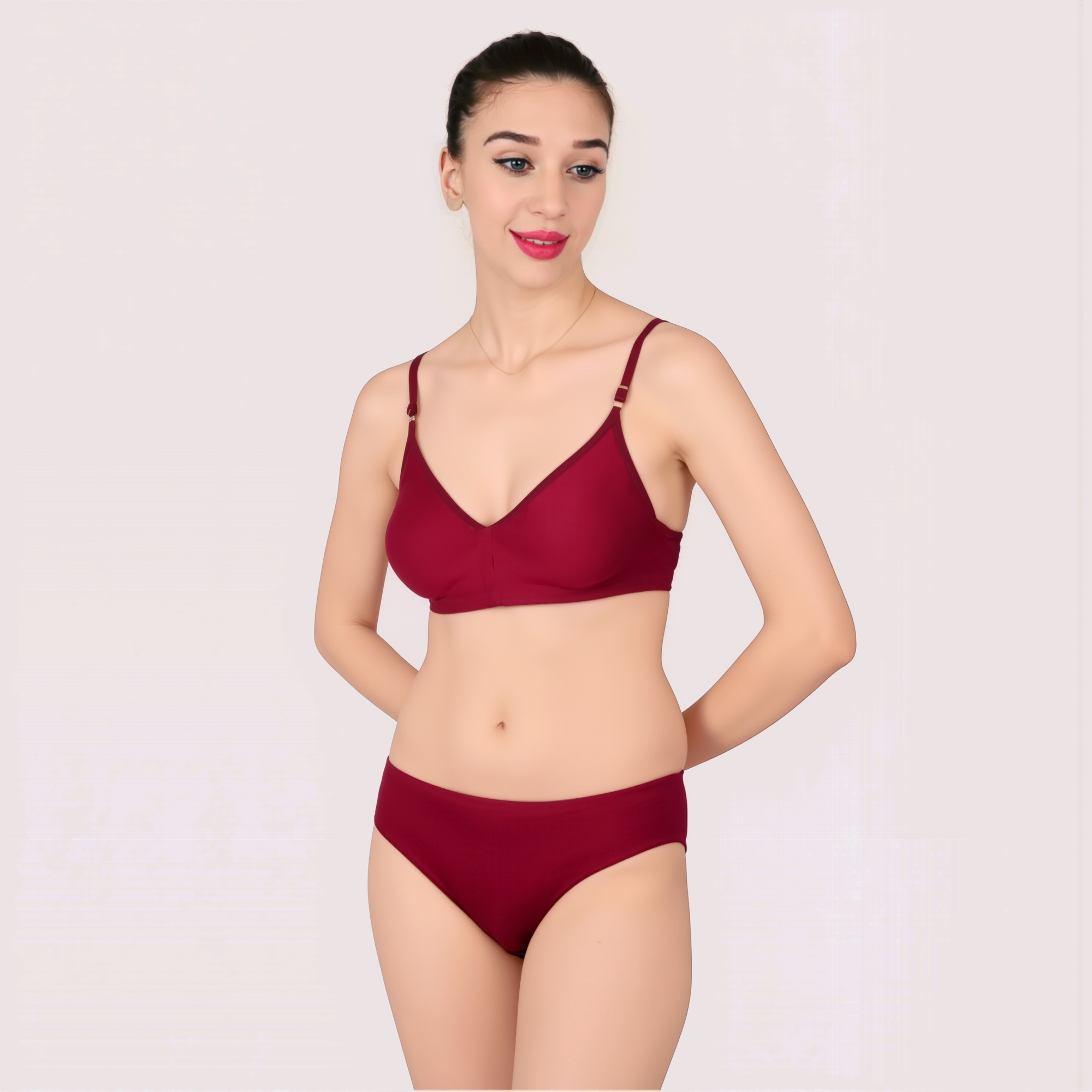 Woman wearing a red bikini set on a light pink background
