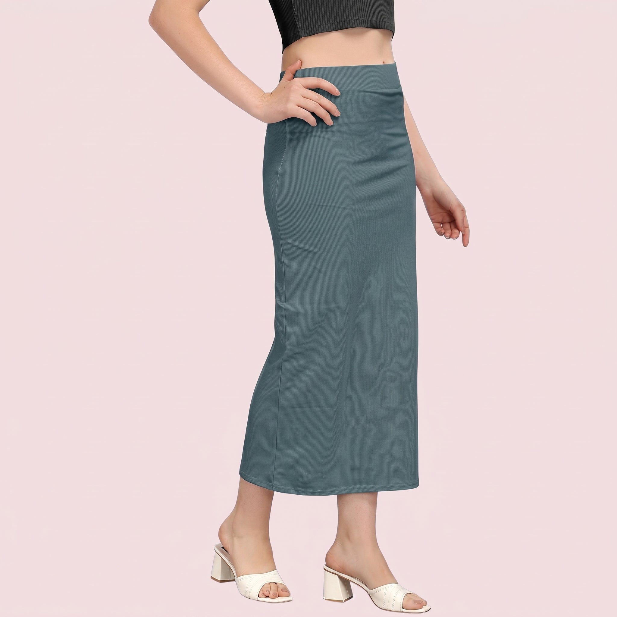 Teal skirt worn by a person on a light pink background