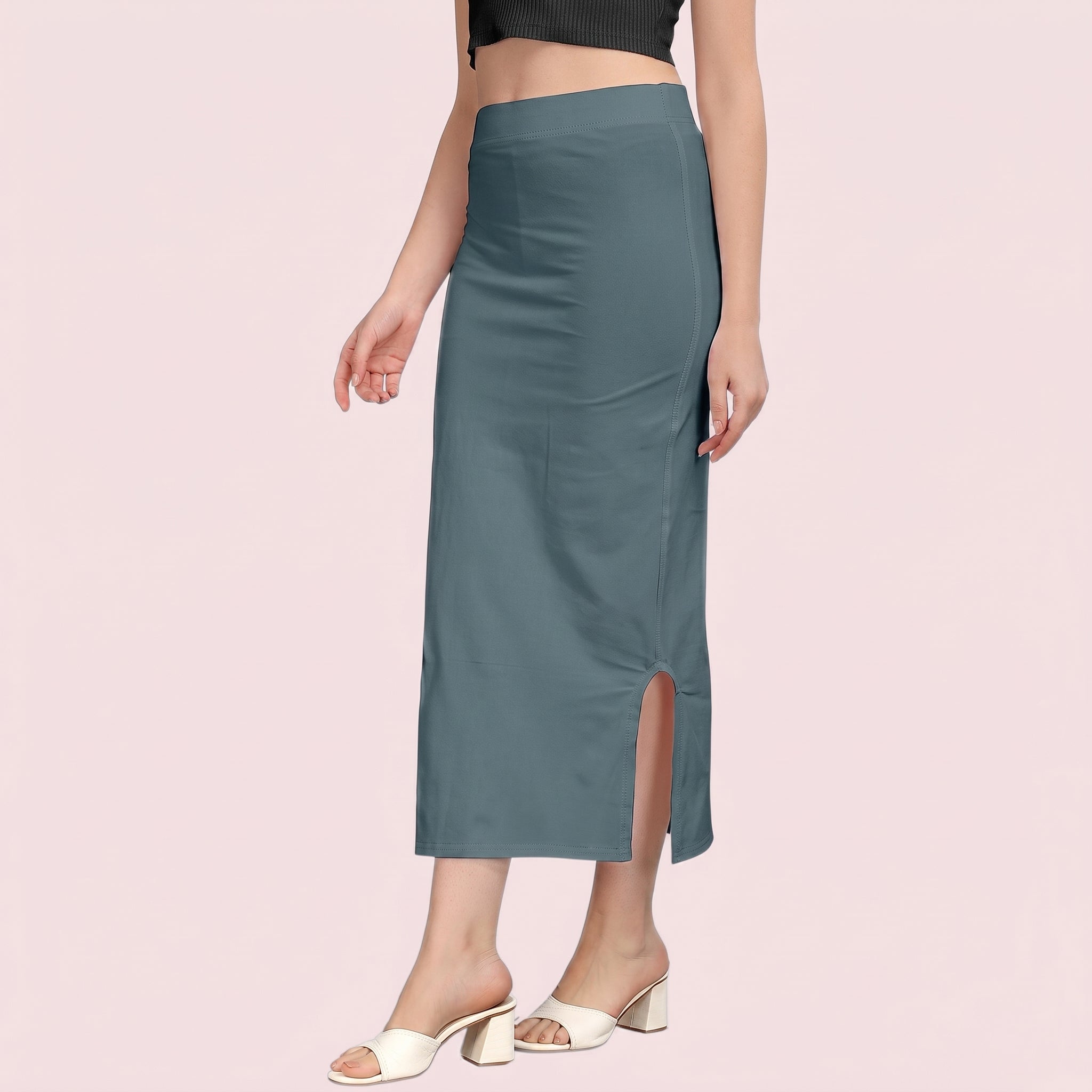 Teal slip skirt worn by a person on a pink background
