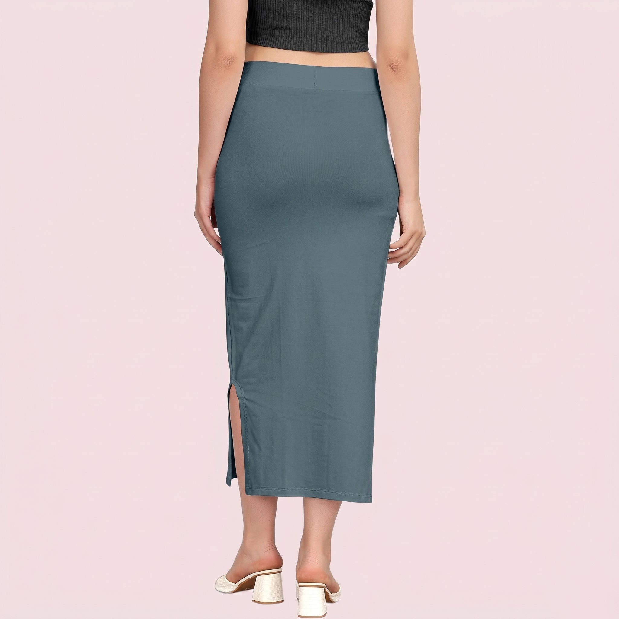 Teal pencil skirt worn by a person on a pink background
