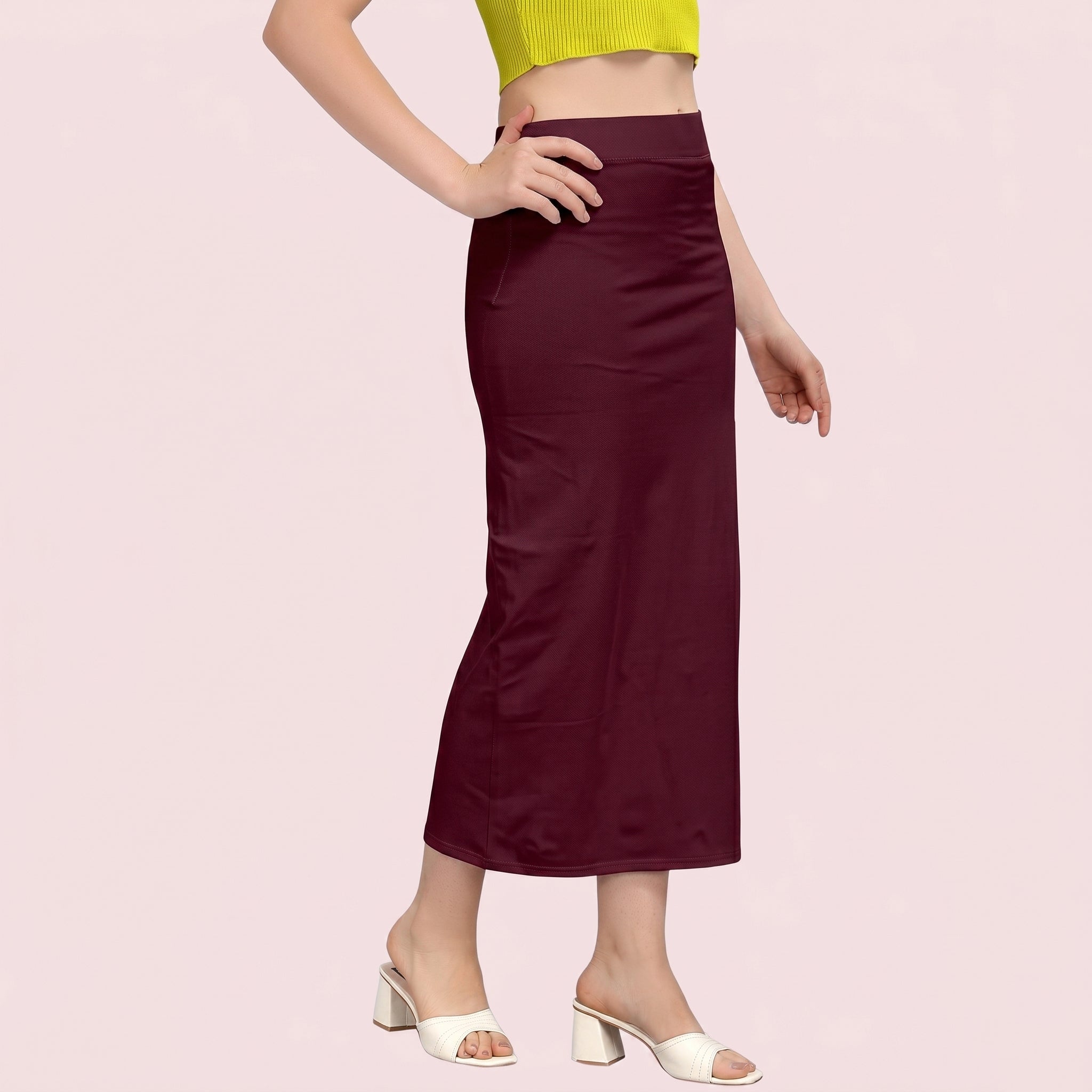 Person wearing a burgundy skirt on a pink background