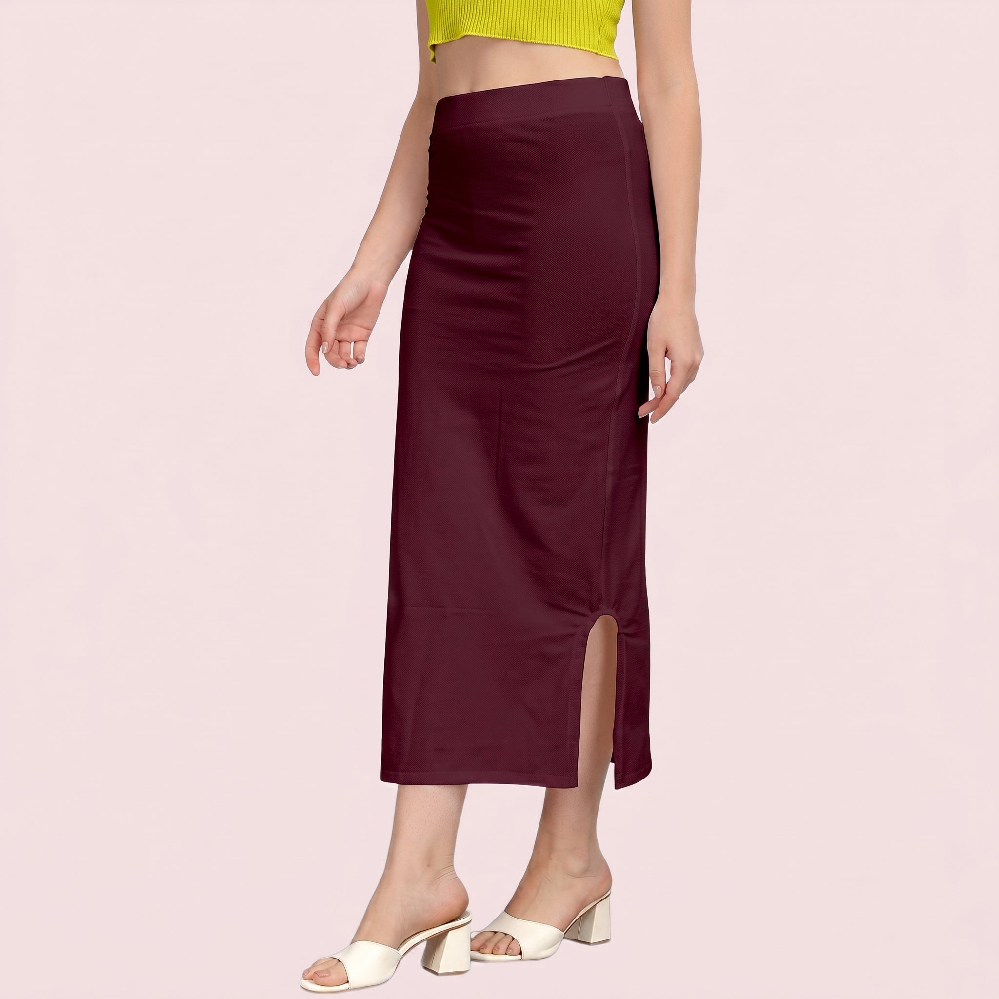 Burgundy slip skirt worn by a person on a light pink background