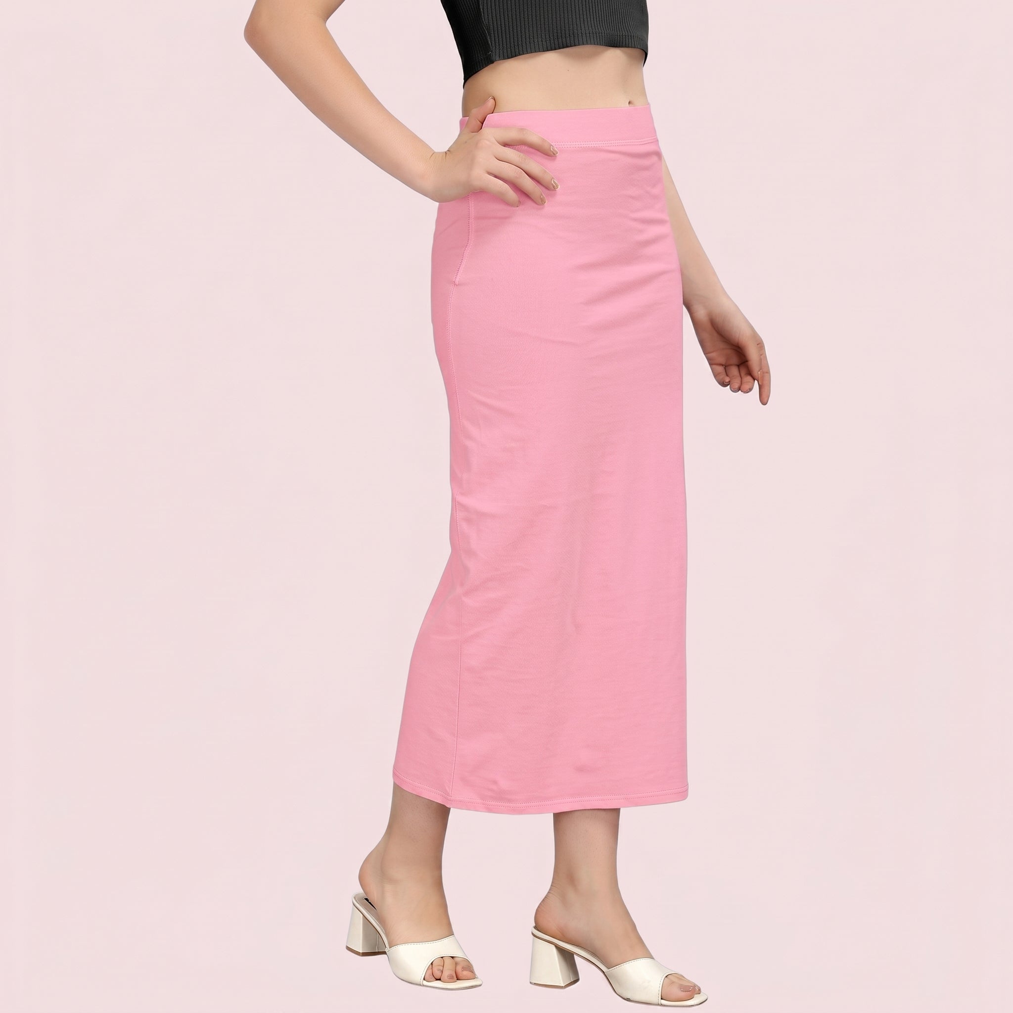 Person wearing a pink skirt on a light pink background