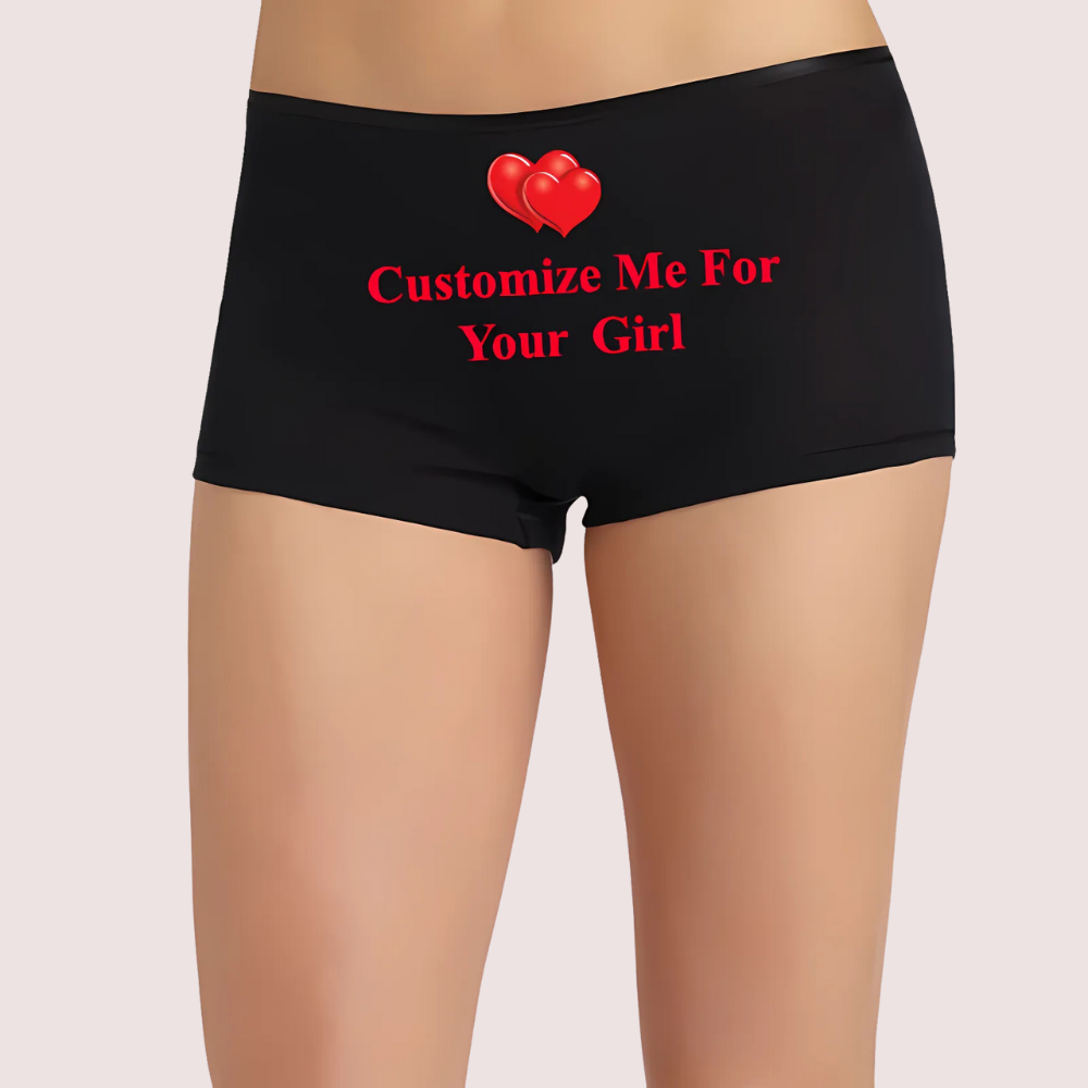 Black underwear with red text and hearts on a beige background